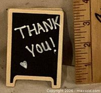 Front of miniature sandwich board showing “THANK YOU!” text next to ruler for scale