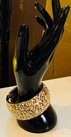 Front view of wide leopard print bangle on display hand