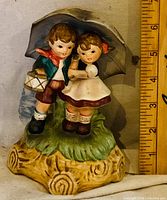 Front view of ceramic music box figurine with ruler for scale