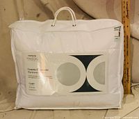 Front view of packaged white queen duvet