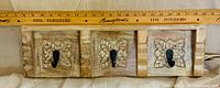 Front view showing three carved panels with hooks and measuring ruler indicating width