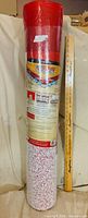 Full view of sealed underlayment roll next to ruler for scale