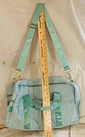 Front view showing overall size with yardstick for scale, detachable shoulder strap attached