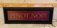 Front view showing PINOT NOIR text, frame color and ruler for scale