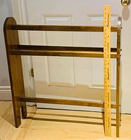 Front view of wooden quilt rack with yardstick for scale