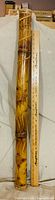 Full view of bamboo rain stick beside 36-in. ruler for scale