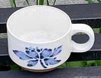 Stoneware cup showing floral motif and handle