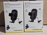 Front view of two boxed Scosche wireless charging phone mounts