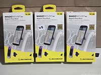 Front view of three boxed Scosche MagicMount Vent phone mounts