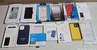 All 12 boxed phone cases laid out, front packaging visible