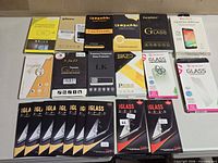Overview of all 21 packaged screen protectors laid out on table