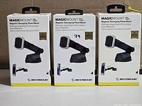 Front view of three retail boxes showing Scosche MagicMount Pro Extendo mounts
