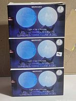 Three stacked boxes of Merkury Innovations LED Earth + Moon Lights