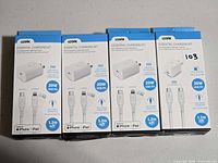 Front view of four boxed Logiix Essential Charging Kits showing power ratings and cable lengths