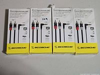 Front view of all four boxed Scosche 6 ft AUX-to-RCA cables