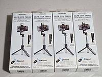 Four boxed Merkury Innovations selfie stick tripods front view
