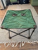 Green fabric folding camping table top view showing cup holders