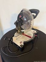 Overall view of Jobmate miter saw showing base, handle, guard and power cord