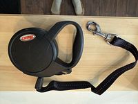 Full view of Flexi retractable dog leash showing housing, handle, leash and snap hook