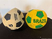 Front view of both soccer balls showing graphics and wear