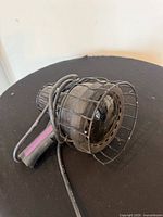 Full view of handheld ultraviolet lamp showing handle, head, protective cage and cord