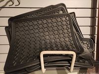 Stacked view showing all four black rubber mats with hexagonal pattern