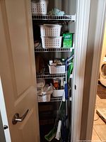 Closet shelves with baskets, Swiffer mop, Bona mop, cleaners and cloths visible