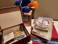 Overview of lot showing apron, books, hoop, organizer and open box of tools