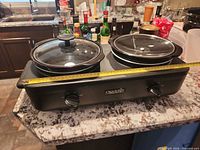 Front view of entire double slow cooker on counter
