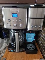 Front view of Cuisinart dual coffee maker showing glass carafe, single-serve section and drip tray