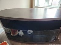 Front view of TV stand showing glass doors and open shelf