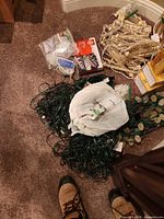 Pile of tangled green string lights, bag with accessories, icicle strands and boxed sets visible