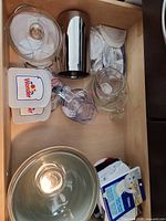 Drawer view showing mixing bowl, casserole lid, stainless holder, Wonder containers, towels, recipe cards