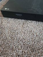 Front left close-up showing LG logo and Ultra HD Blu-ray labeled disc tray