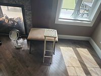 Bench, plant stand, and vanity mirror grouped on floor