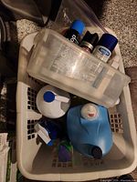 Top view of laundry basket with various cleaners and tote