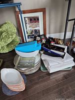 Group view of framed art, stacked plates, linens, napkin rings, bowls