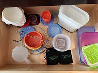 Drawer view showing bowls, cups, lids, containers, rack, funnel, koozies