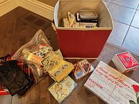 Overall lot showing red storage cube, card decks, utensils, gloves, fabrics