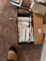 Box containing Wii Remotes, Nunchuk, cables