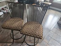 Front view of both bar stools showing seat upholstery and slatted backs