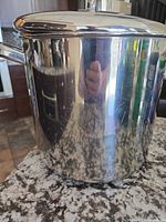 Front view of polished stainless stockpot showing side handle and overall condition