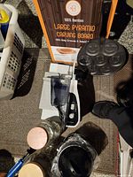 Entire lot showing Rival slicer, Bambusi carving board box, pancake pan, glass jars, blender parts