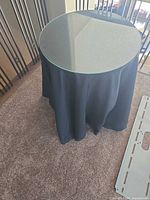 Top view showing circular clear glass surface and draped fabric