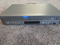 Front view of Samsung DVD-V3500 combo player showing DVD and VHS slots, control panel, and AV inputs