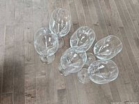 Six clear glass red wine glasses lying on floor