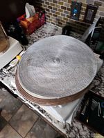 Stack of round silver and brown braided placemats