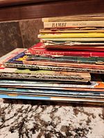 Stack of approximately twenty thin children's picture books showing wear