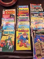 Overview of both stacks of assorted vintage comics showing front covers