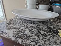 platter on metal stand with stacked bowls in background